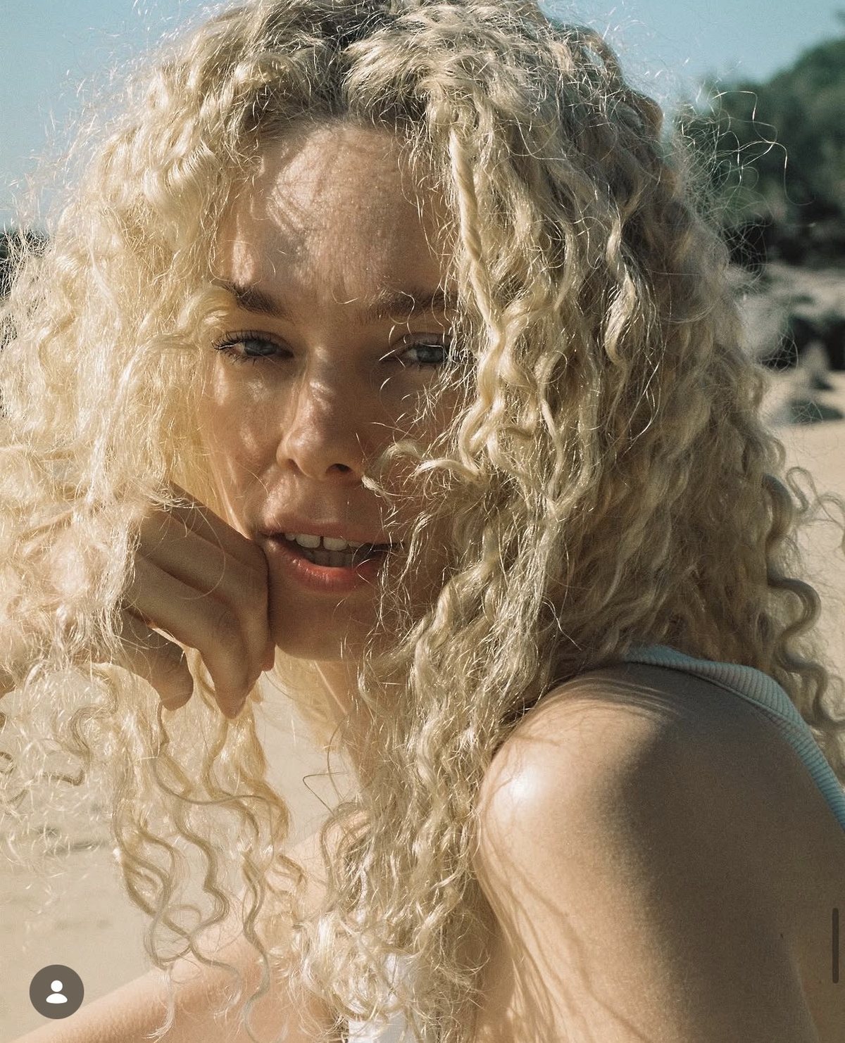 Shann, smiling in bright natural sunlight